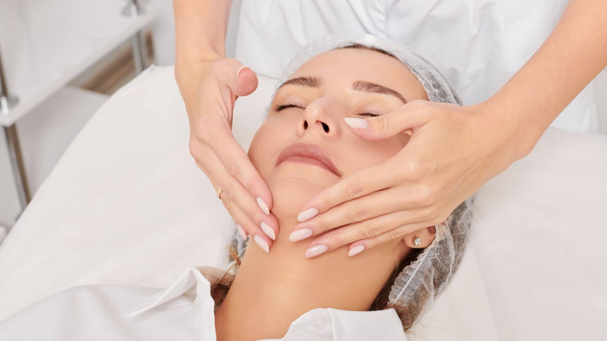 Fisioterapeuta realizando masaje de Drenaje Linfático Facial a una paciente